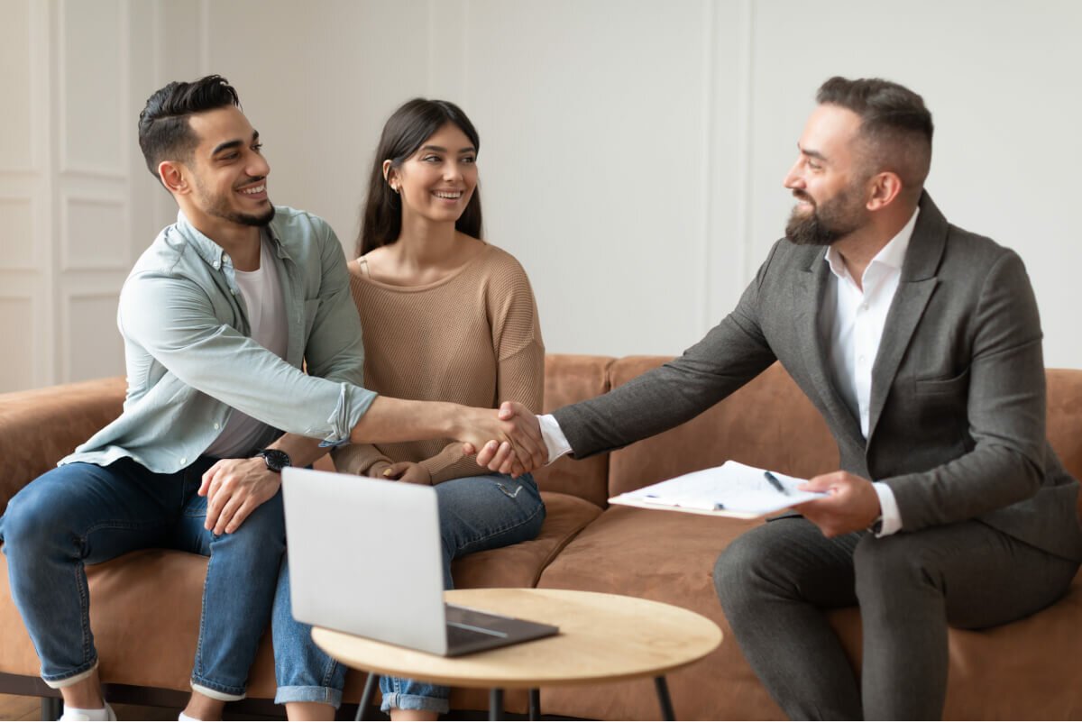 A couple shaking hands with their Vaultra advisor after opening a new account